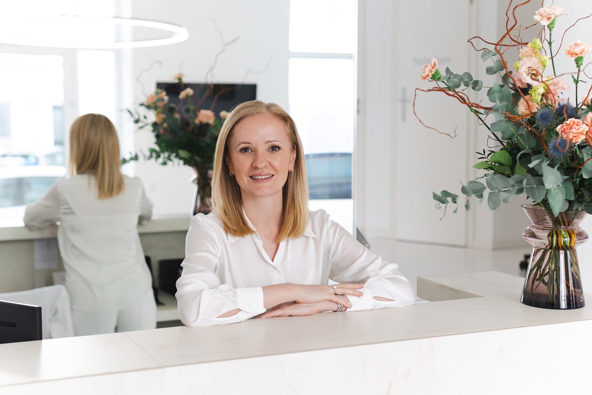 Dr. Madalina Werneke am Empfangstresen bei VIVIDA Lab in München.