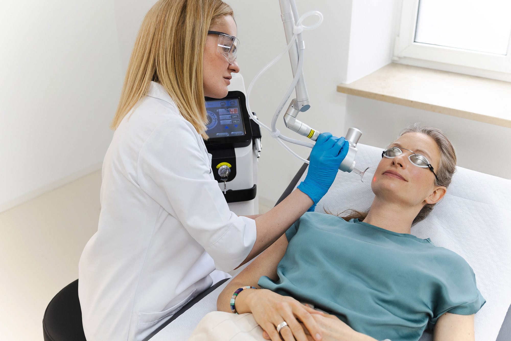 Dr. Madalina Werneke führt eine CO2-Laserbehandlung bei einer Patientin durch.