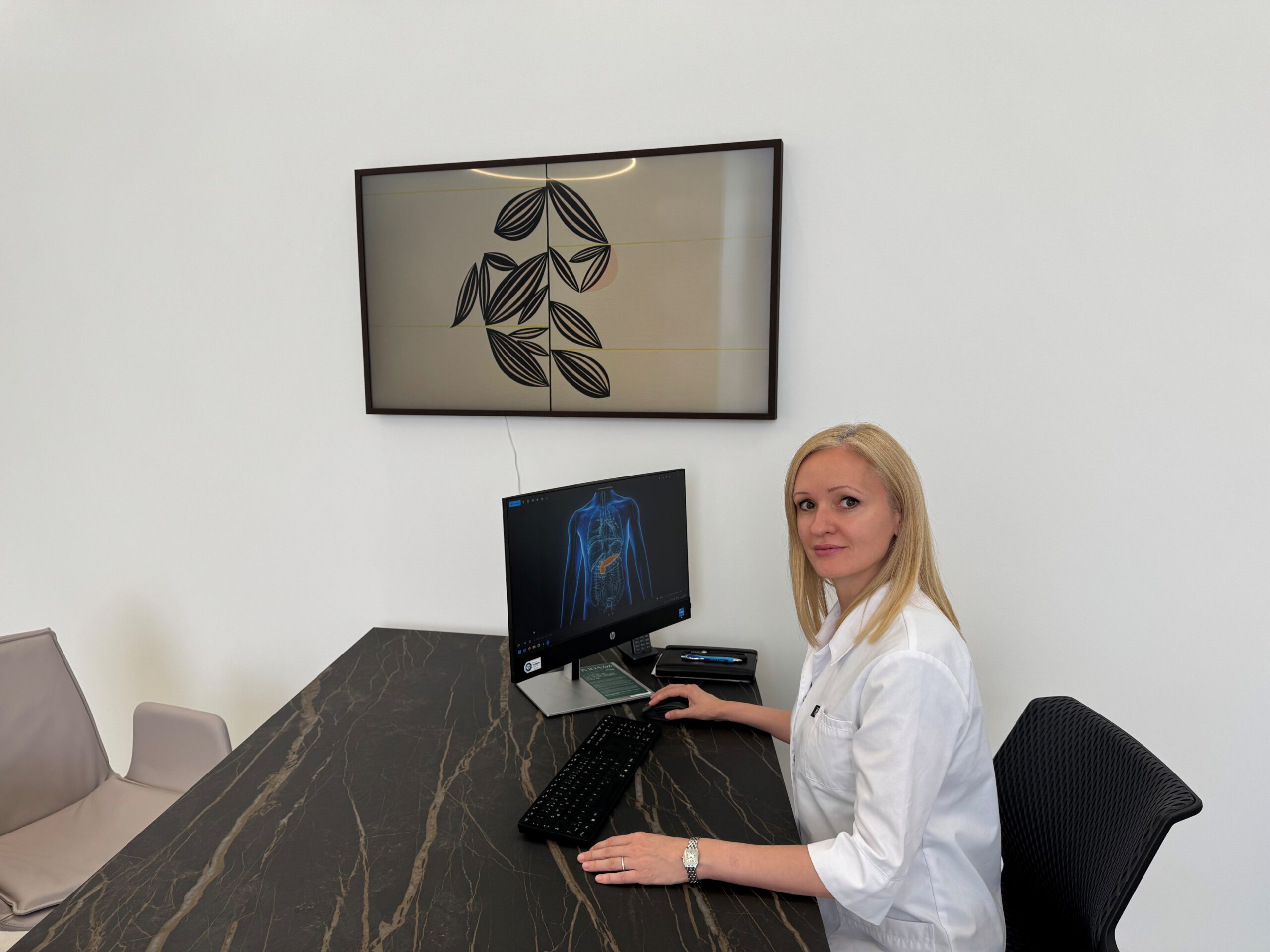 Madalina Werneke sitzt an ihrem Schreibtisch in der Praxis